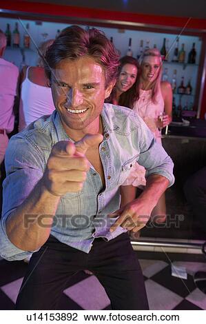Stock Image - Young Man Having Fun In Busy Bar. Fotosearch