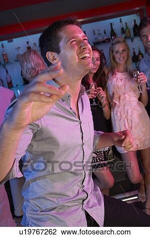 Stock Image - Young Man Having Fun In Busy Bar. Fotosearch