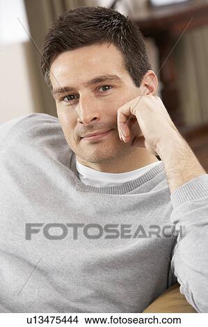 Picture - Young Man Relaxing In Chair At Home. Fotosearch