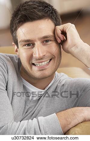 Picture - Young Man Relaxing In Chair At Home. Fotosearch