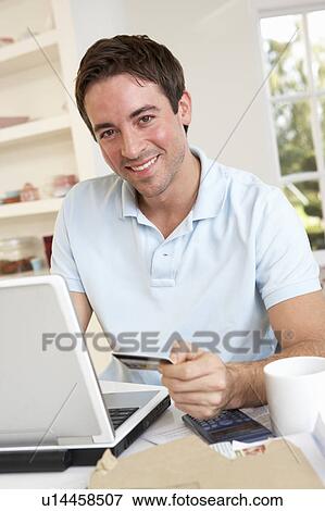 Young man using credit card on the internet View Large Photo Image Stock Photo - Young man using credit card on the internet. Fotosearch