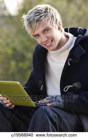 Stock Image - Young man with laptop computer. Fotosearch