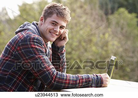 Young man with laptop computer View Large Photo Image Stock Image - Young man with laptop computer. Fotosearch
