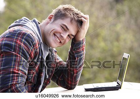 Stock Photograph - Young man with laptop computer. Fotosearch