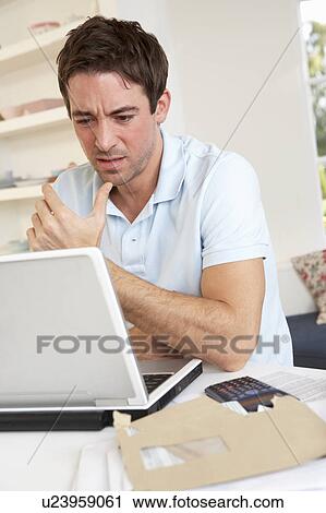 Stock Image - Young man working with laptop computer. Fotosearch