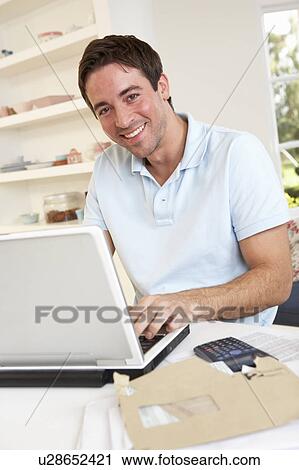 Stock Image - Young man working with laptop computer. Fotosearch