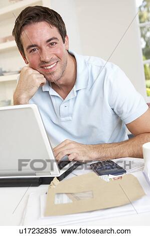 Stock Photography - Young man working with laptop computer. Fotosearch