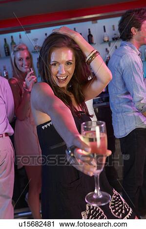 Stock Image - Young Woman Having Fun In Busy Bar. Fotosearch