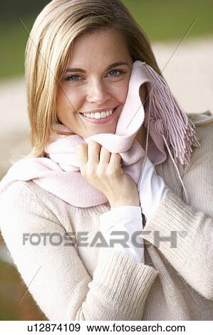 Stock Photo - Young woman having portrait with scarf outside looking at camera. Fotosearch