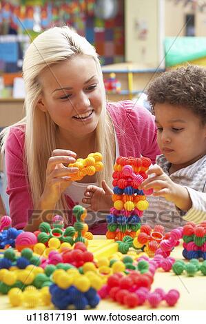 Young woman playing with boy View Large Photo Image Stock Image - Young woman playing with boy. Fotosearch