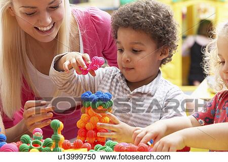 Young woman playing with boy View Large Photo Image Stock Image - Young woman playing with boy. Fotosearch