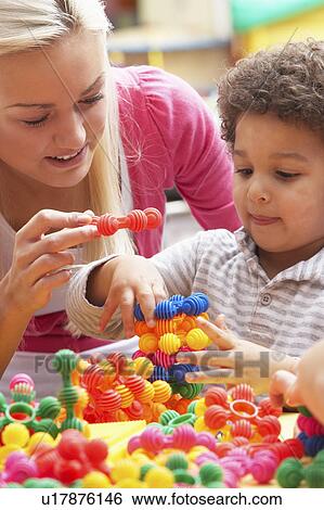 Young woman playing with boy View Large Photo Image Stock Photograph - Young woman playing with boy. Fotosearch