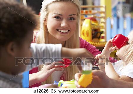 Stock Photography - Young woman playing with boy. Fotosearch