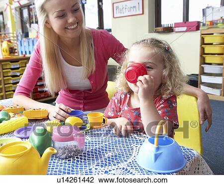 Stock Image - Young woman playing with girl. Fotosearch