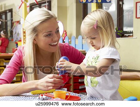 Stock Photograph - Young woman playing with girl. Fotosearch
