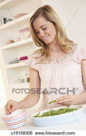 Young woman splitting pea in kitchen View Large Photo Image Stock Photograph - Young woman splitting pea in kitchen. Fotosearch