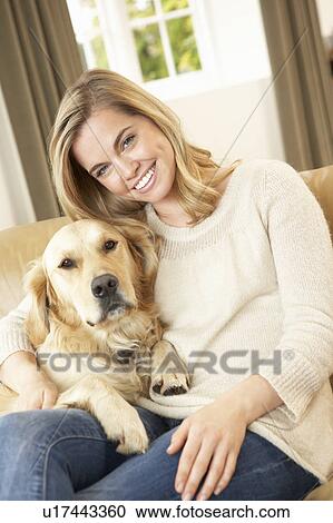 Young woman with dog sitting on sofa View Large Photo Image Stock Image - Young woman with dog sitting on sofa. Fotosearch