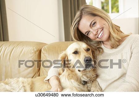 Young woman with dog sitting on sofa View Large Photo Image Stock Image - Young woman with dog sitting on sofa. Fotosearch