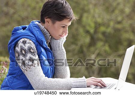 Stock Image - Young woman with laptop computer. Fotosearch