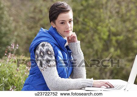 Stock Image - Young woman with laptop computer. Fotosearch