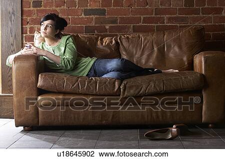 Young woman with phone on sofa View Large Photo Image Stock Image - Young woman with phone on sofa. Fotosearch
