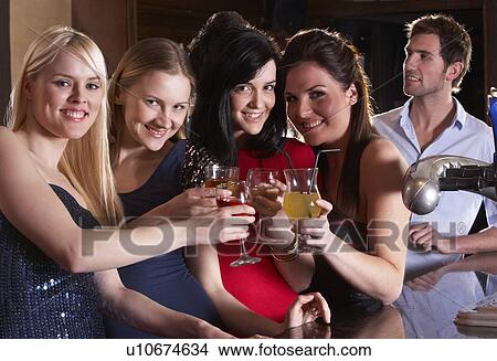 Young women drinking at bar View Large Photo Image Picture - Young women drinking at bar. Fotosearch