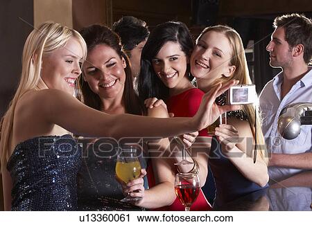Stock Image - Young women drinking at bar. Fotosearch