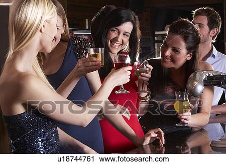 Young women drinking at bar View Large Photo Image Stock Image - Young women drinking at bar. Fotosearch