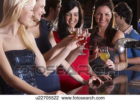 Young women drinking at bar View Large Photo Image Stock Image - Young women drinking at bar. Fotosearch
