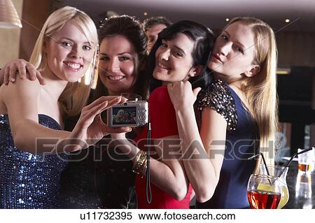 Young women posing at party View Large Photo Image Stock Photography - Young women posing at party. Fotosearch