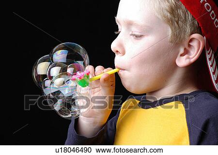 Stock Image - Boy blowing bubbles. Fotosearch