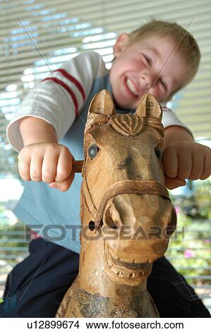 Picture - Boy on rocking horse. Fotosearch