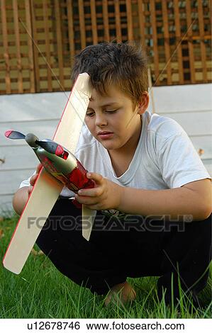 Stock Photograph - Boy playing with toy plane. Fotosearch