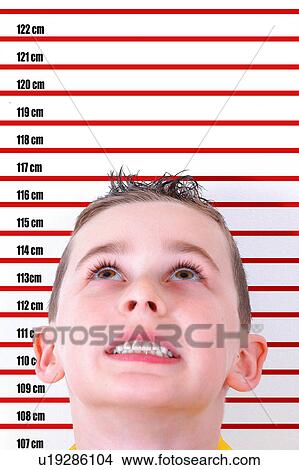 Picture - Boy standing in front of height chart. Fotosearch