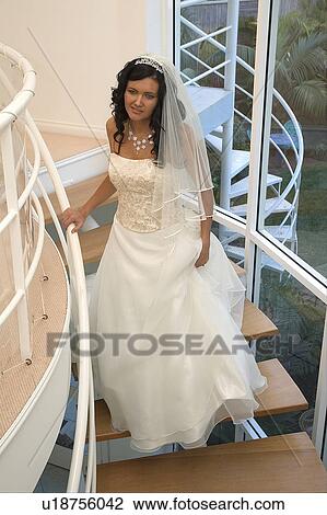 Stock Image - Bride coming down staircase. Fotosearch