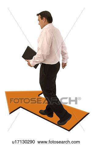 Stock Image - Business man walking on an arrow. Fotosearch