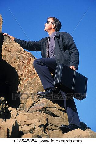 Businessman climbing a rock mountain View Large Photo Image Picture - Businessman climbing a rock mountain. Fotosearch