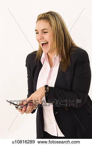 Stock Photo - Businesswoman holding a cell phone and laughing. Fotosearch