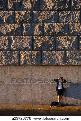 Stock Photograph - Businesswoman in front of a concrete wall. Fotosearch
