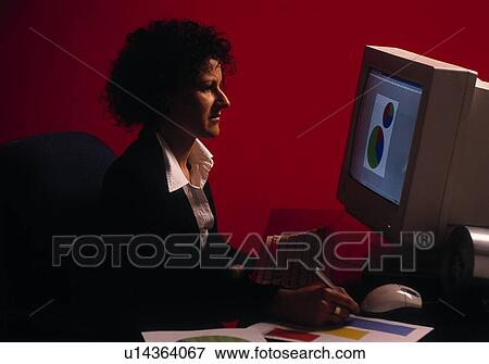 Stock Photo - Businesswoman working on pie charts on a computer. Fotosearch