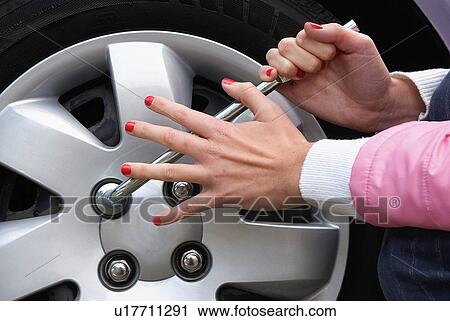 Stock Image - Changing a flat tire. Fotosearch