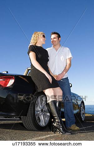 Stock Photography - Couple at beach by a car. Fotosearch