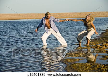 Stock Photo - Couple playing in the water. Fotosearch
