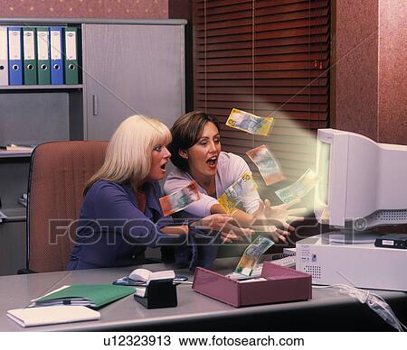 Stock Image - Coworkers catching money falling out of computer. Fotosearch