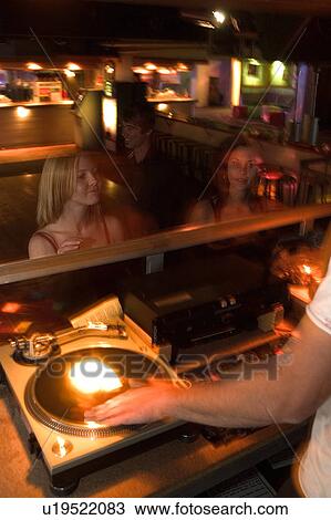 Stock Image - DJ at nightclub. Fotosearch