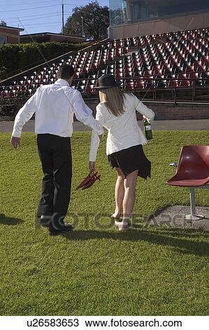 Stock Image - Drunk couple at the races. Fotosearch