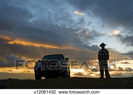 Stock Image - Farmer at sunset. Fotosearch