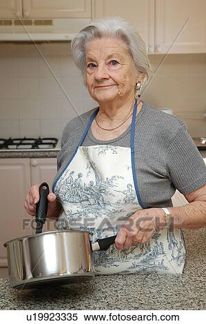Stock Photography - Grandma cooking dinner. Fotosearch