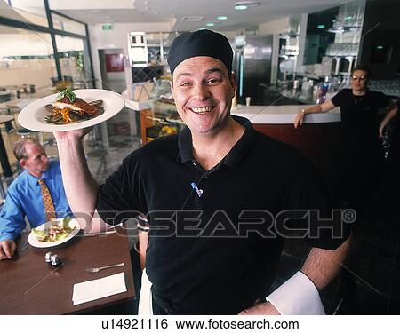 Stock Photograph - Happy waiter in a restaurant. Fotosearch
