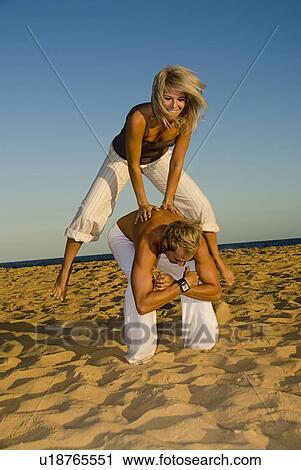 Stock Image - Leap frog on the beach. Fotosearch